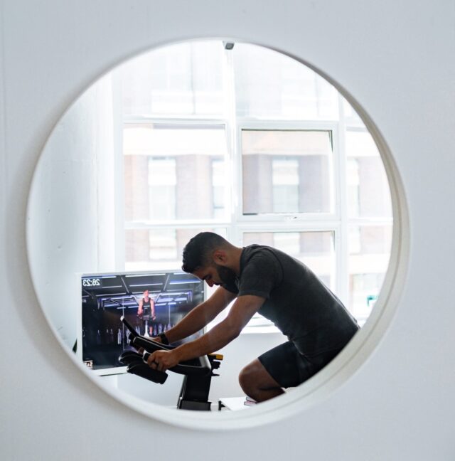 Image of a man on an indoor bike engaged in a workout, demonstrating dedication and commitment to fitness