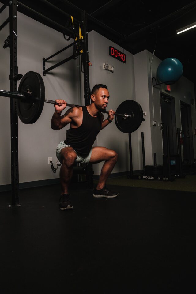 Man performing a barbell squat with impeccable form, showcasing strength, stability, and proper technique in the exercise.