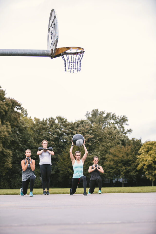 Four women having an outdoor boot camp workout